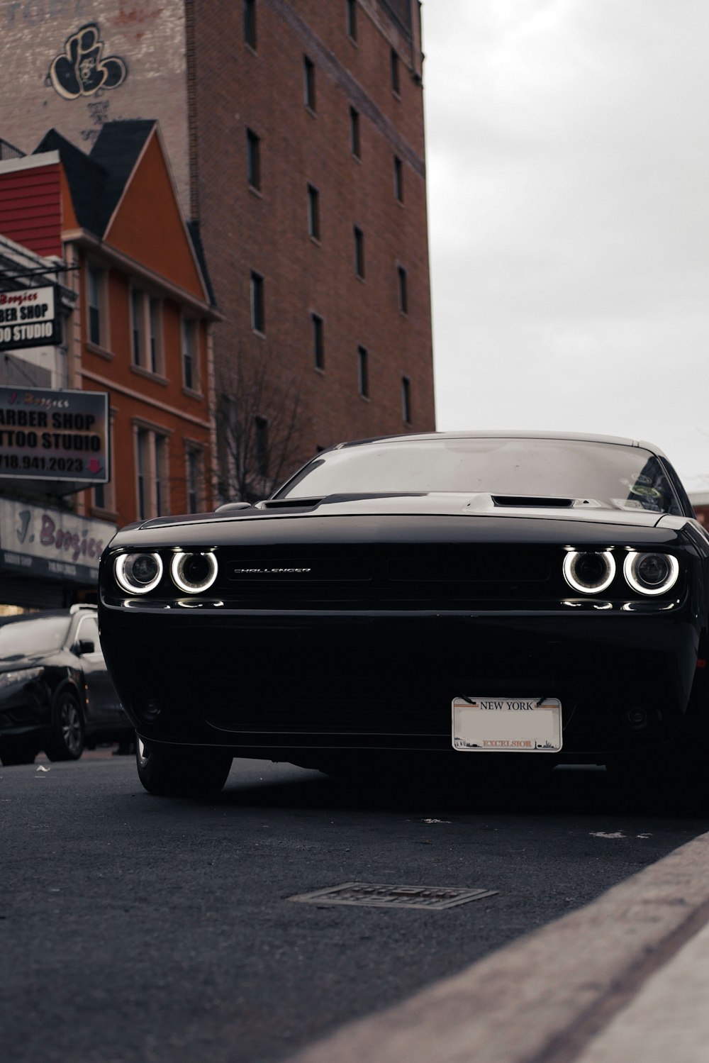 black bmw car parked beside brown building during daytime