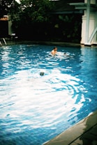A serene swimming pool with a coach guiding a student in the water.