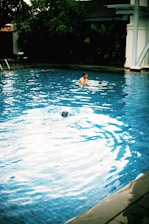 A serene swimming pool with a coach guiding a student in the water.