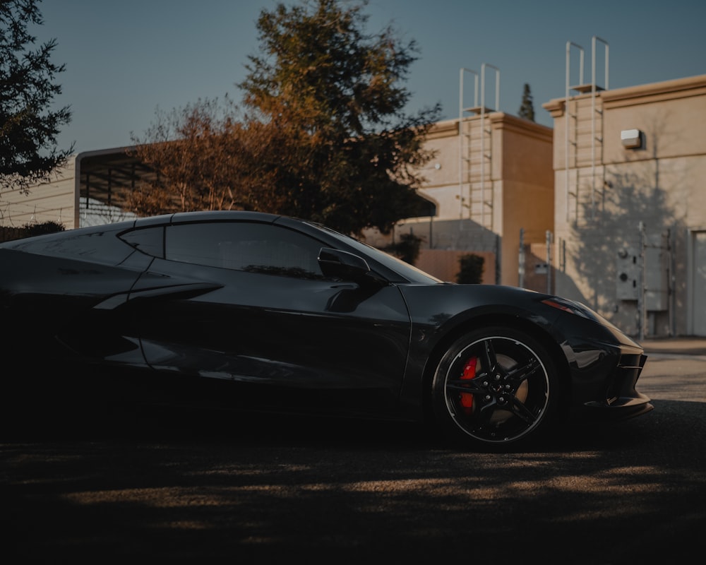 black coupe parked near brown building during daytime