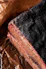 Close-up of a juicy smoked brisket slice with a dark, flavorful bark on a rustic wooden board.
