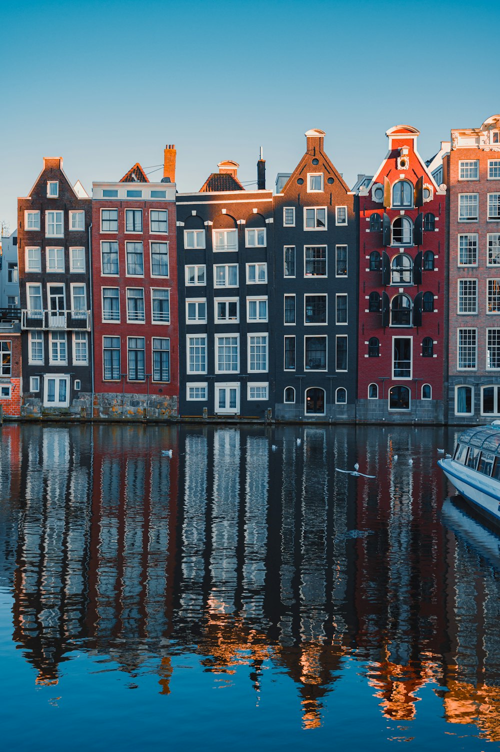 red and white concrete building beside body of water during daytime