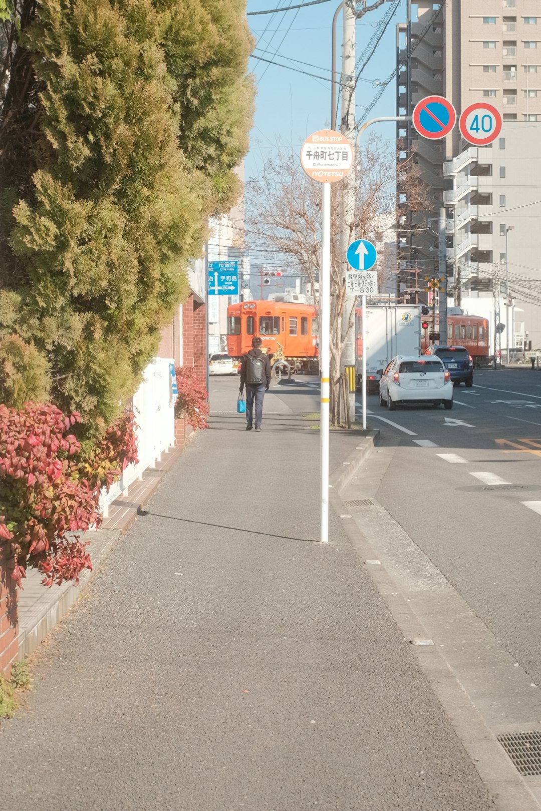 man in black jacket and black pants walking on sidewalk during daytime