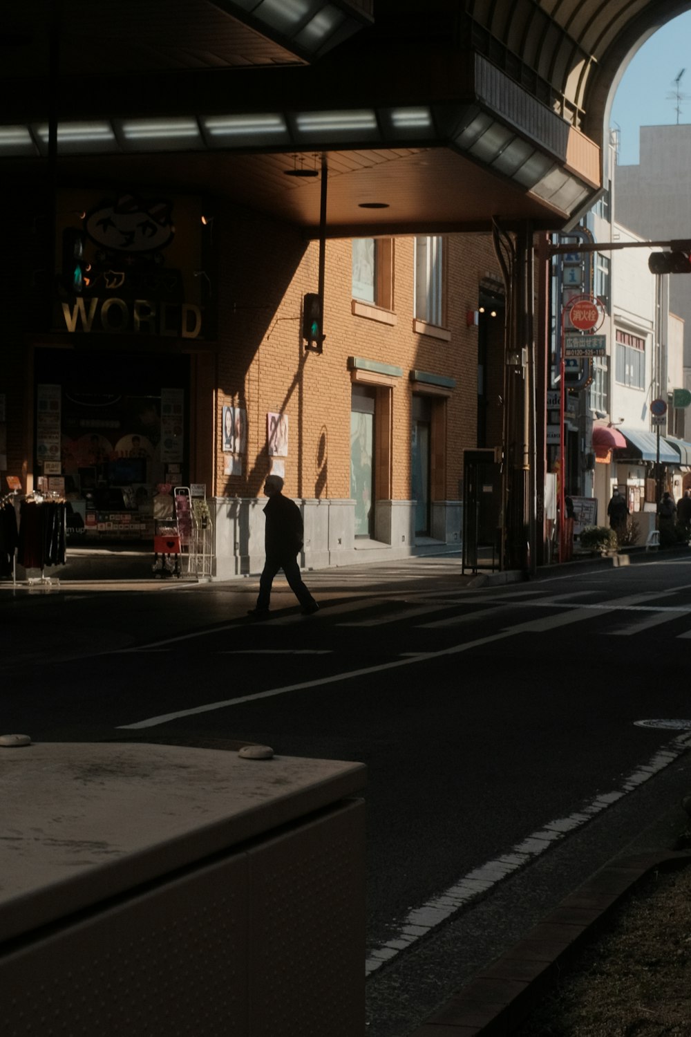 man in black jacket walking on sidewalk during night time