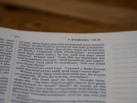 A close-up view of an open page from a book, focusing on text from a chapter in the Bible, specifically 1 Samuel 14:42-44. The page appears to be well-lit and the text is in clear serif font. The right side of the page includes lined annotations.