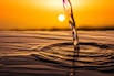 water drop on brown sand during sunset