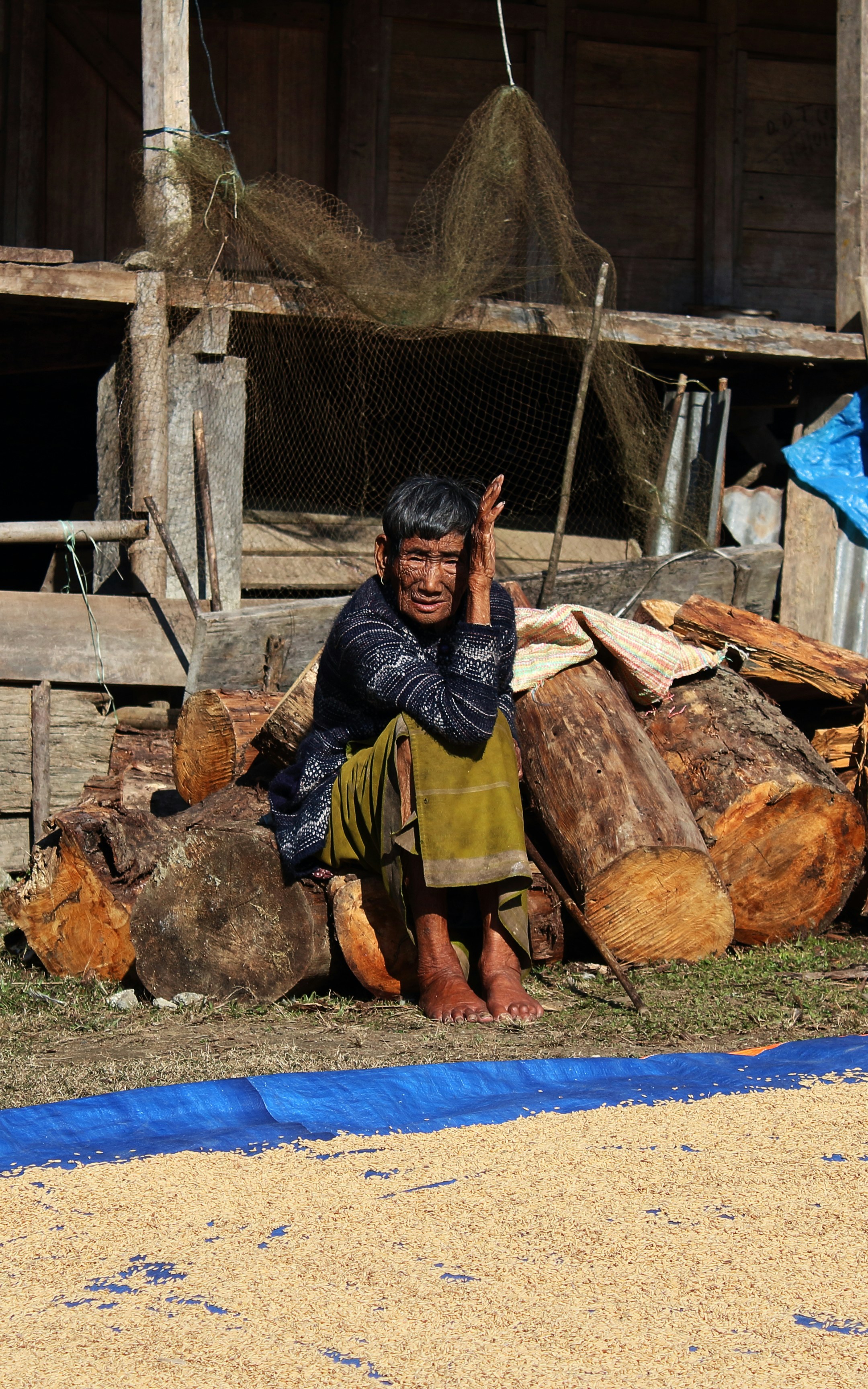 man in black and gray plaid dress shirt sitting on brown wood log