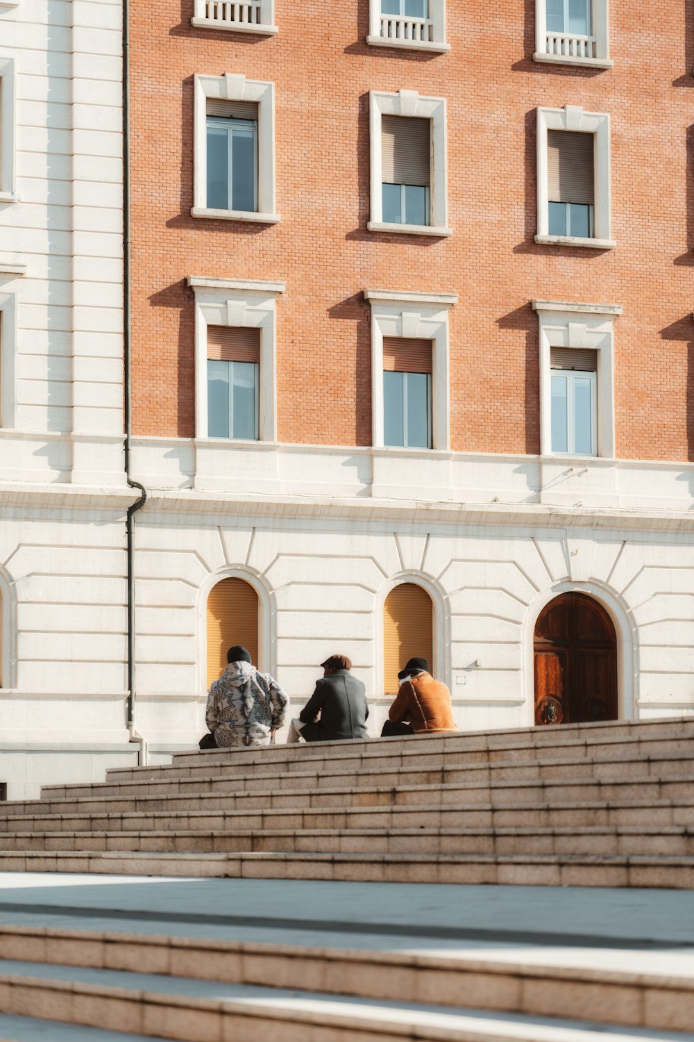 people walking on sidewalk near brown concrete building during daytime