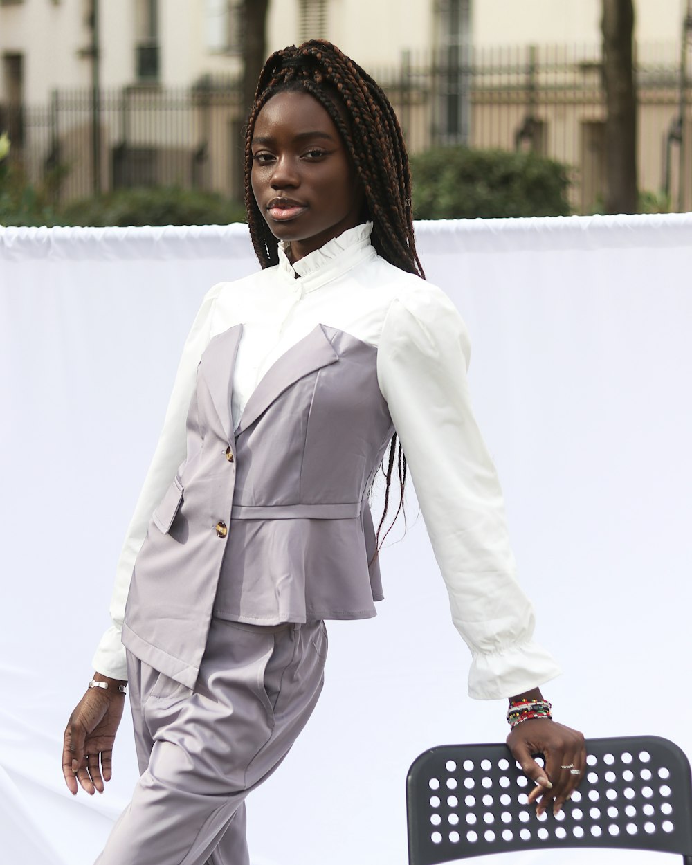 woman in white blazer holding black skateboard