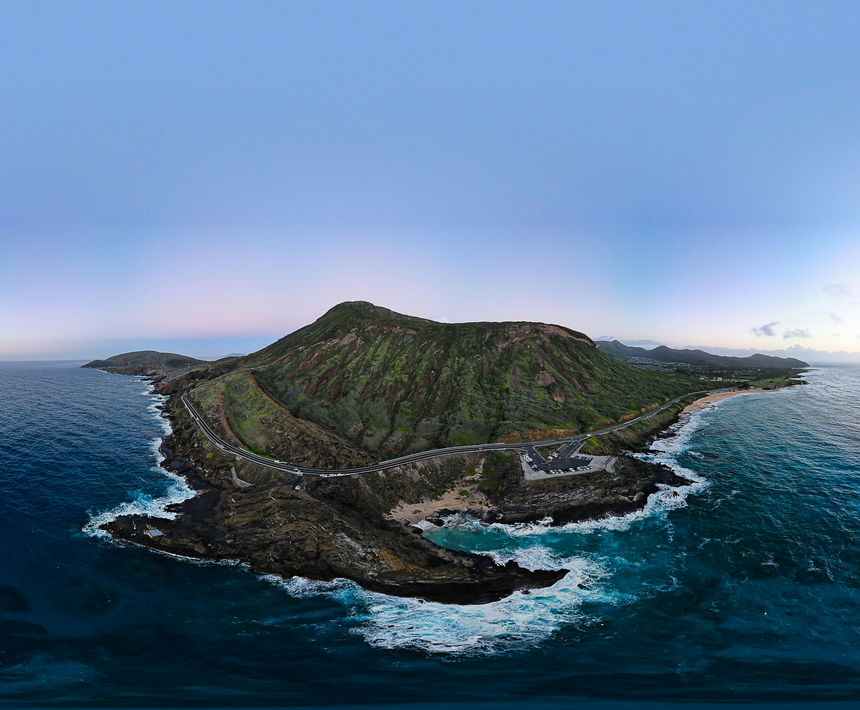 green mountain beside blue sea under blue sky during daytime