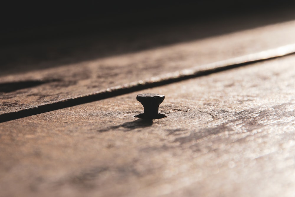 black steel round ornament on brown wooden surface