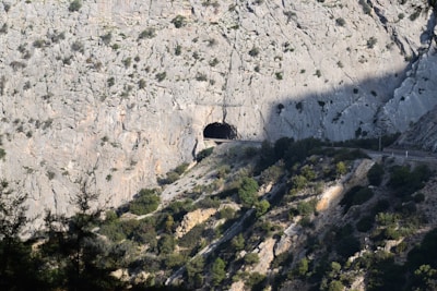 A detailed shot of a tunnel entrance carved into rugged mountain terrain, highlighting structural design.