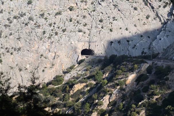 Aerial shot of a modern tunnel entrance carved through a mountainous region.