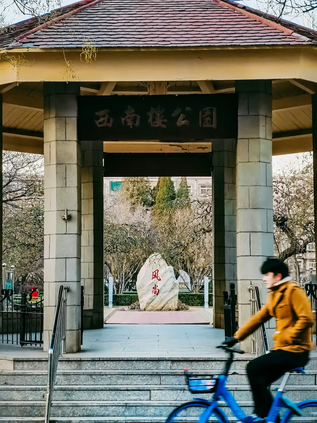 man in yellow jacket sitting on black bench