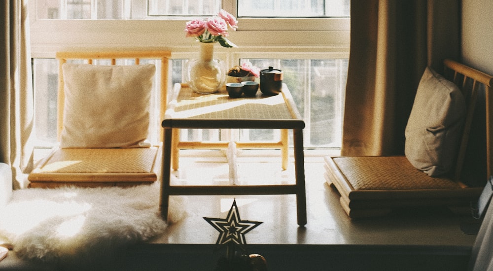 white and brown wooden table with white and pink flower on top