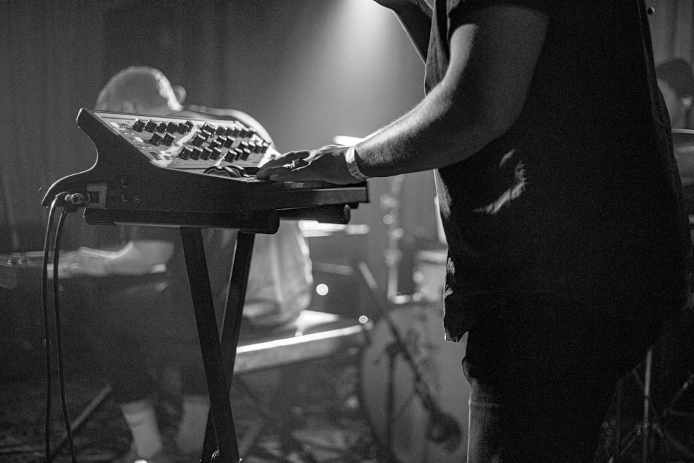 grayscale photo of man in t-shirt holding tray with food