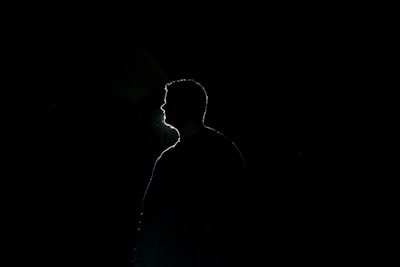 silhouette of man standing in dark room