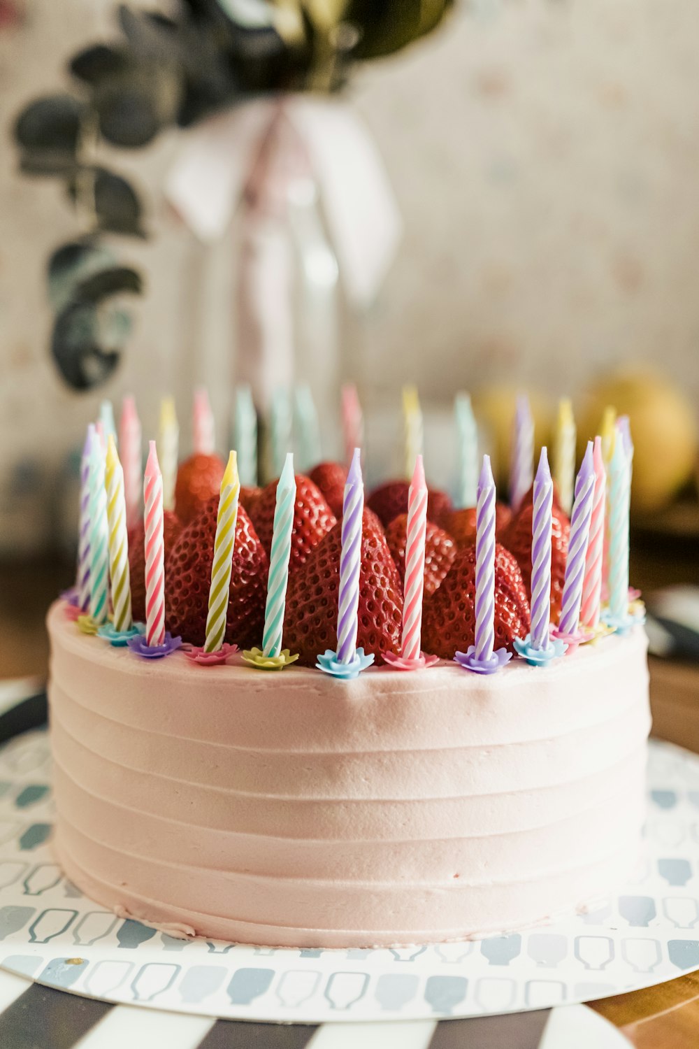 white and pink cupcake with assorted color candles