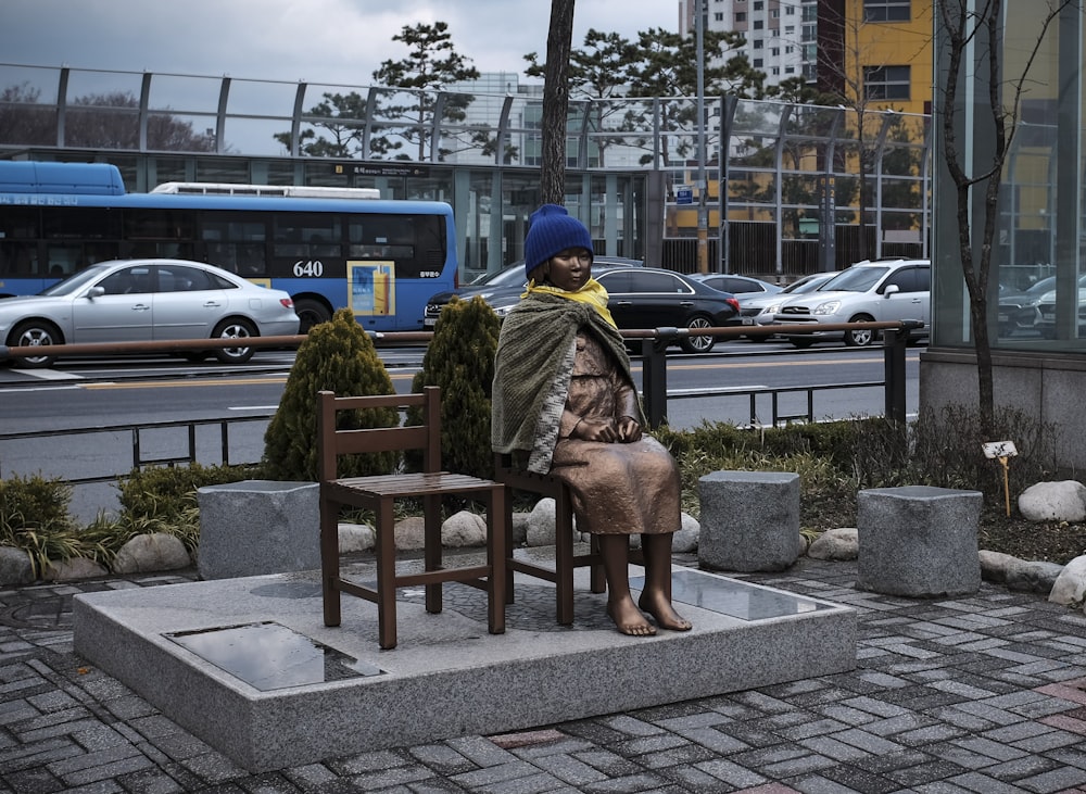 woman in brown coat sitting on brown wooden bench