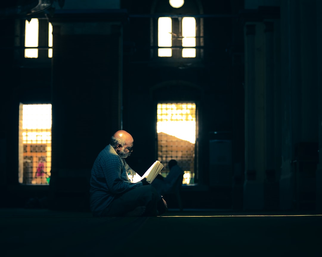 man in blue dress shirt sitting on chair