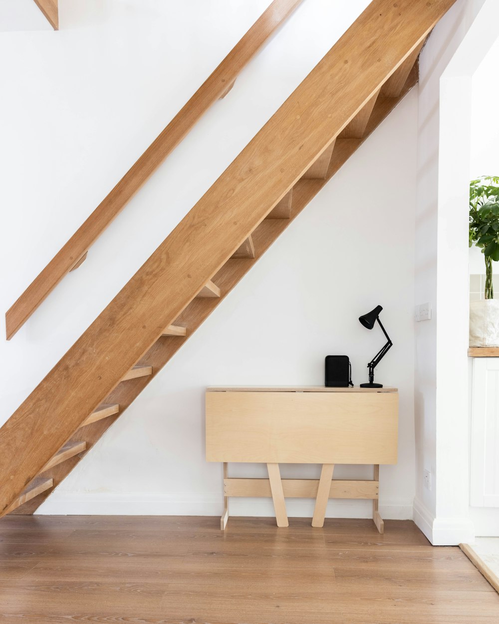 brown wooden table near white wall