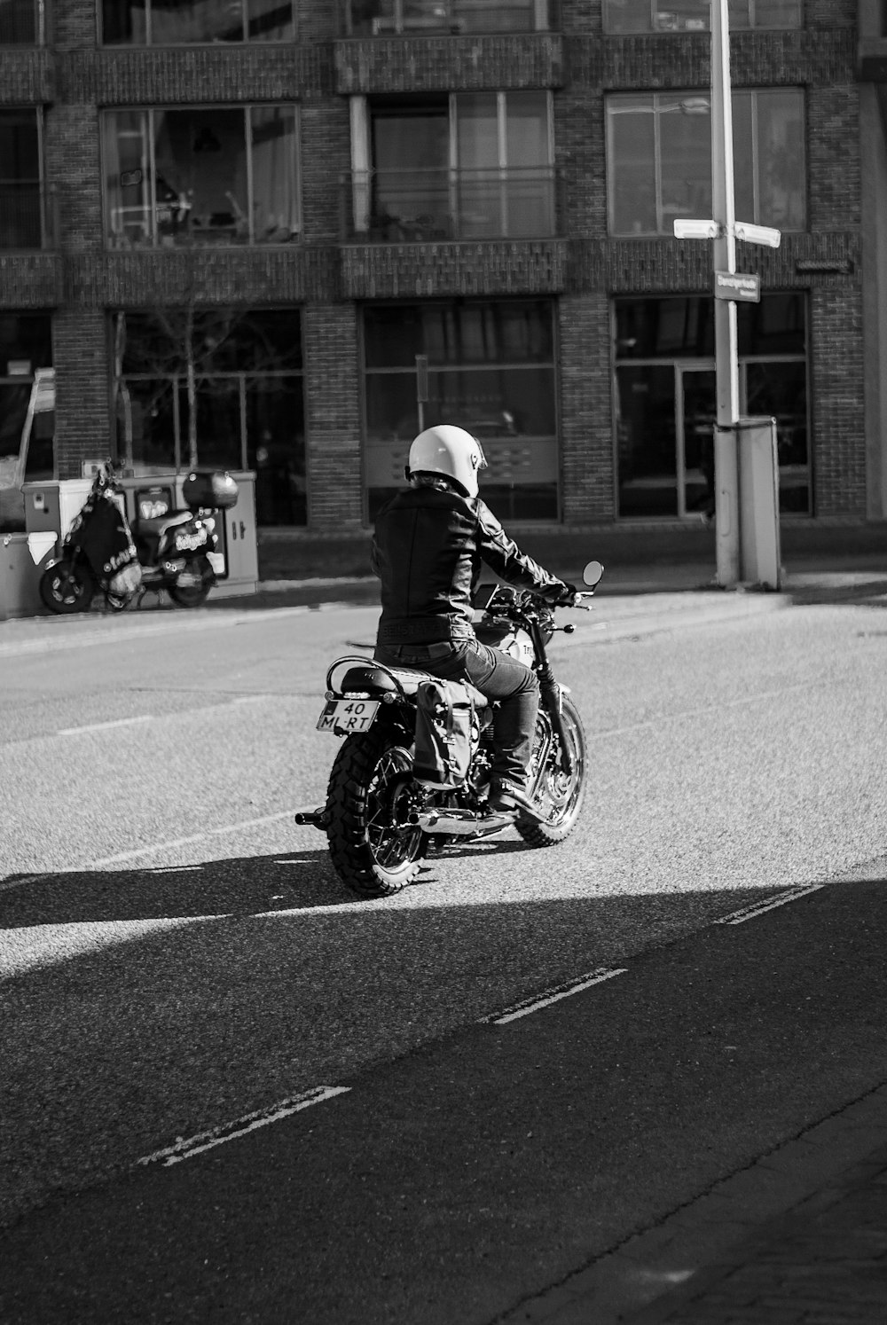 grayscale photo of man riding motorcycle