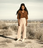 woman in brown scarf standing on brown field during daytime