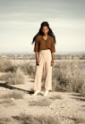 woman in brown scarf standing on brown field during daytime