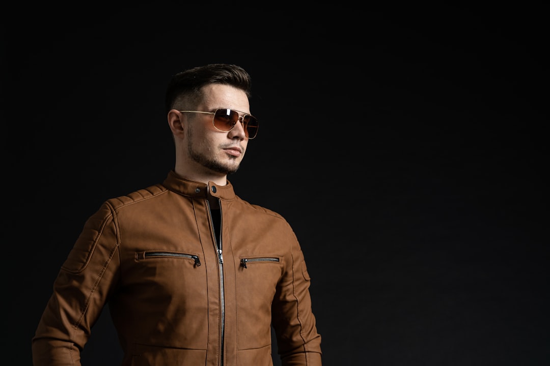 man in brown leather zip up jacket wearing black sunglasses