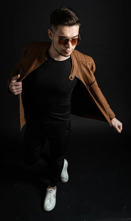 man in black tank top and brown jacket