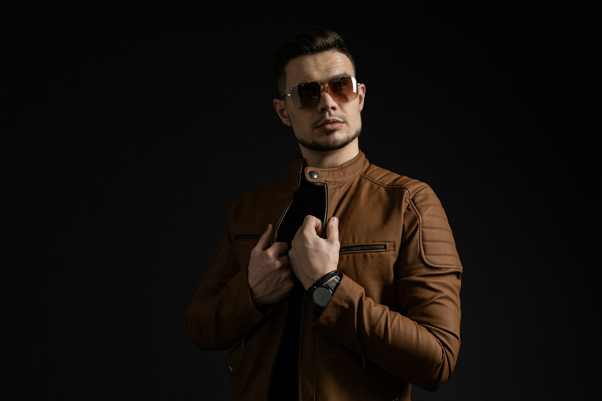 man in brown leather jacket wearing black sunglasses