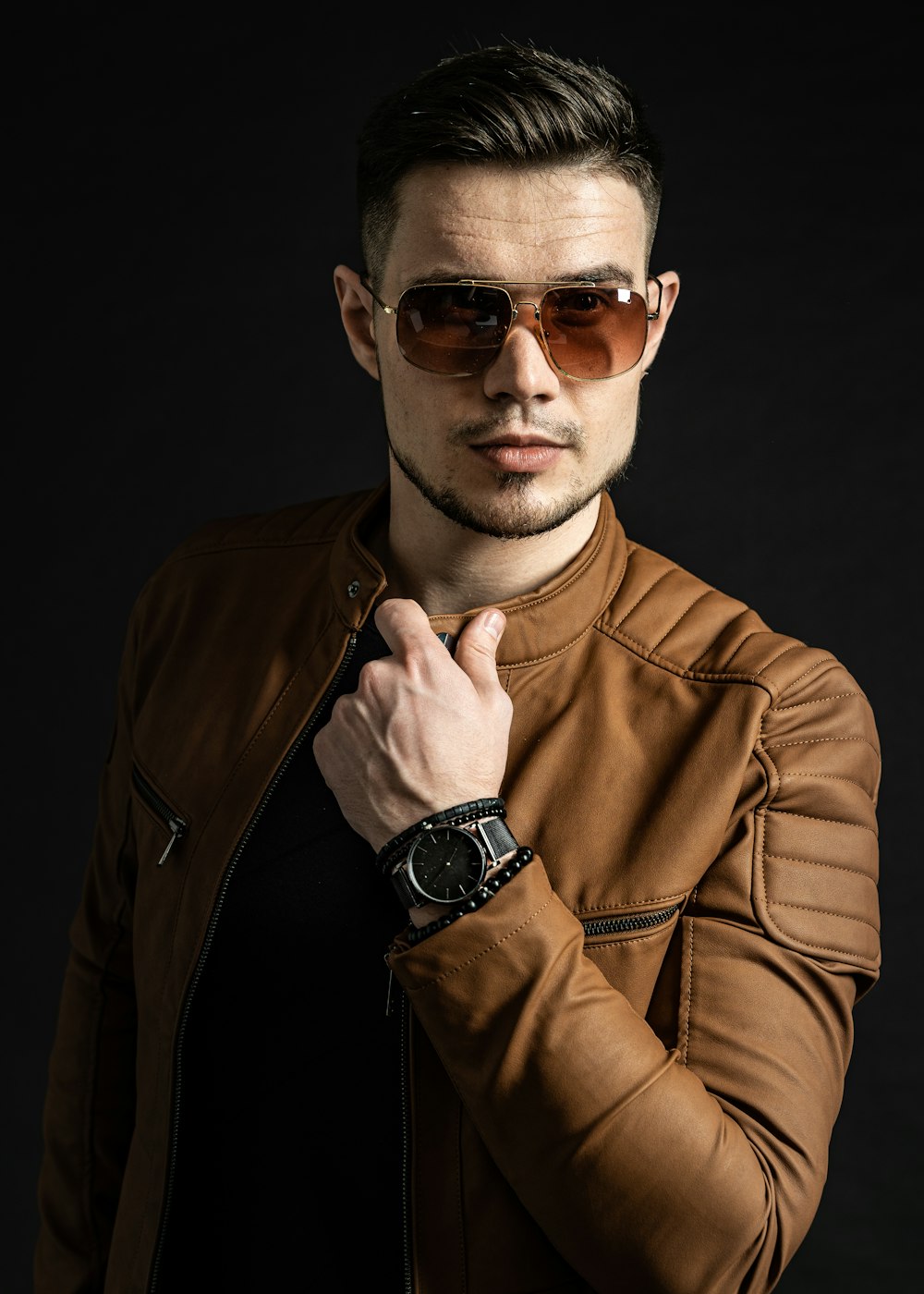 man in brown leather jacket wearing black sunglasses