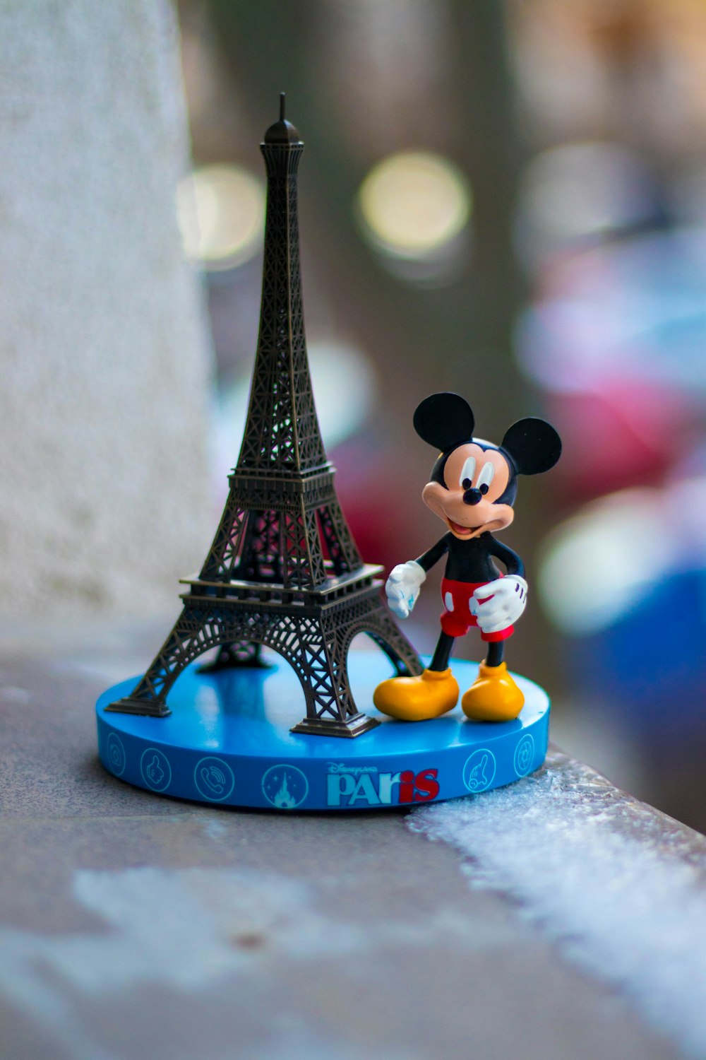 Figurine de Mickey Mouse à côté de la Tour Eiffel Miniature