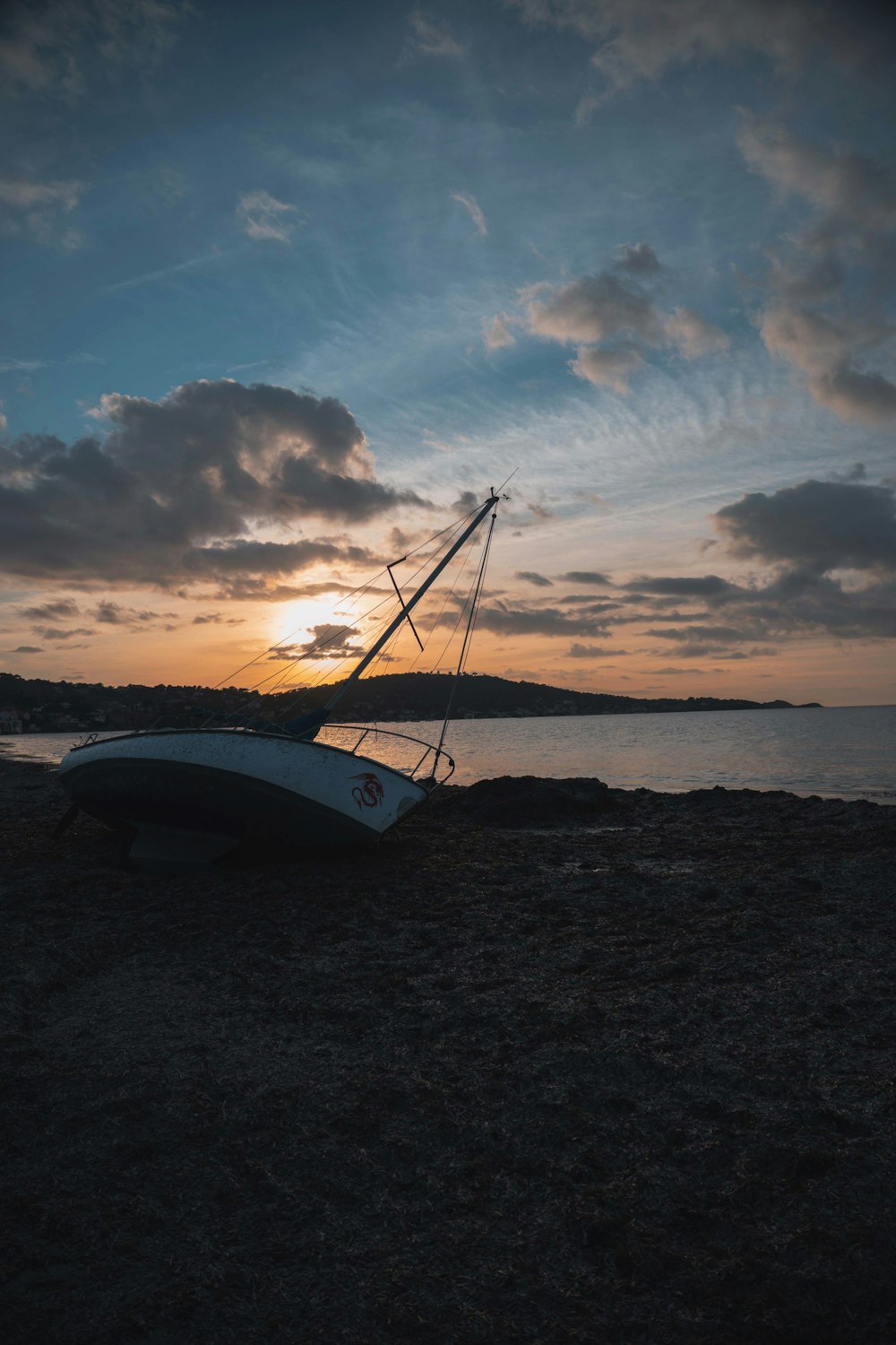 white boat on brown sand during sunset