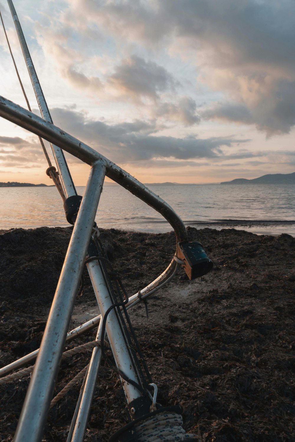 black metal railings on brown sand near body of water during daytime