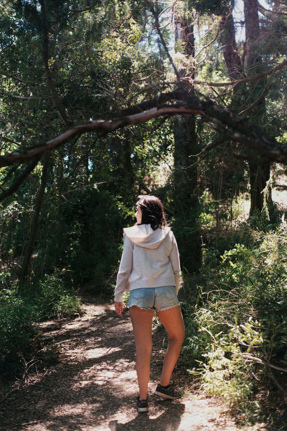 woman in white shirt standing on brown tree