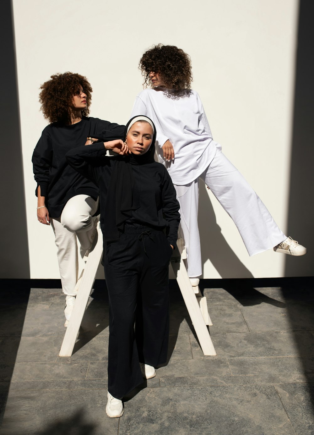 man in black long sleeve shirt and white pants standing beside woman in white long sleeve