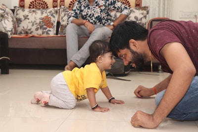 A father and child joyfully playing with educational toys on the floor.