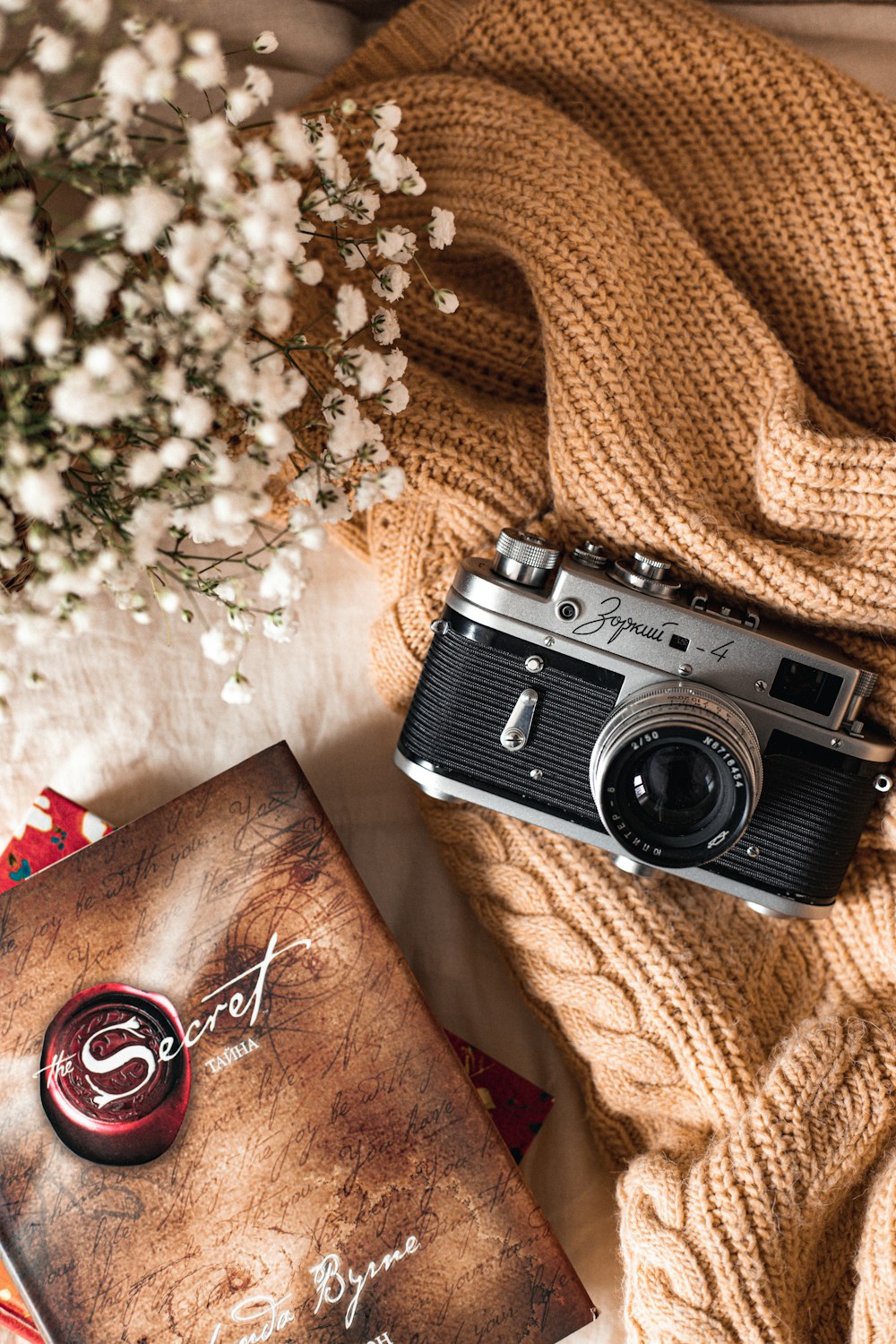 black and silver camera on brown textile