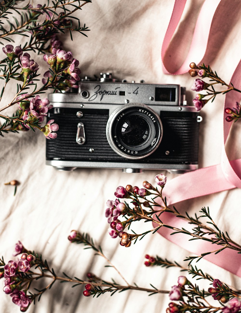 black and silver camera on white and pink floral textile