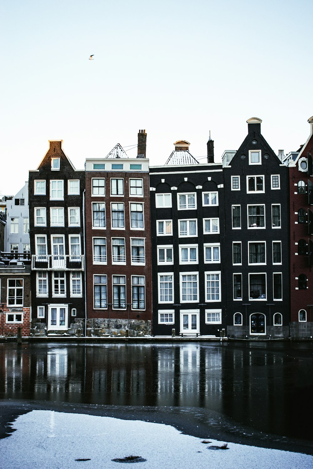 red and white concrete building near body of water during daytime