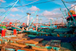 The busy port with fishing boats docked under a bright sky.