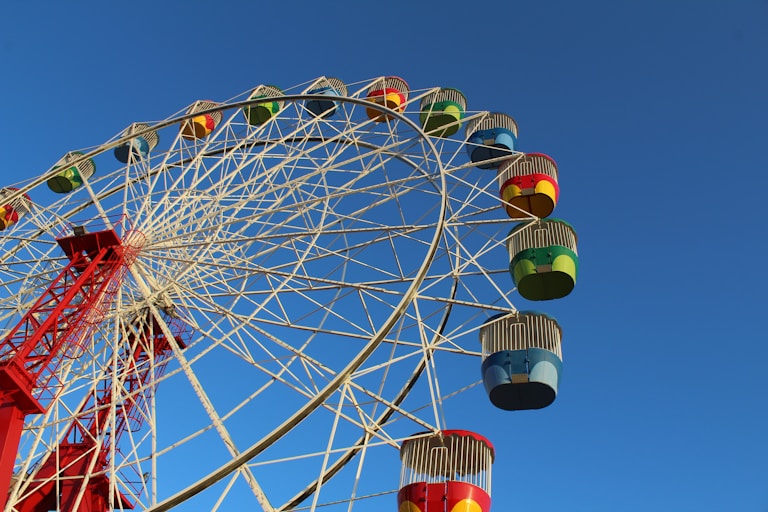 white and red ferris wheel under blue sky during daytime