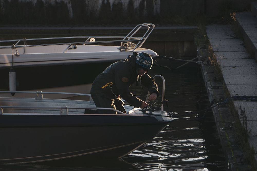 man in black jacket riding on white boat during daytime