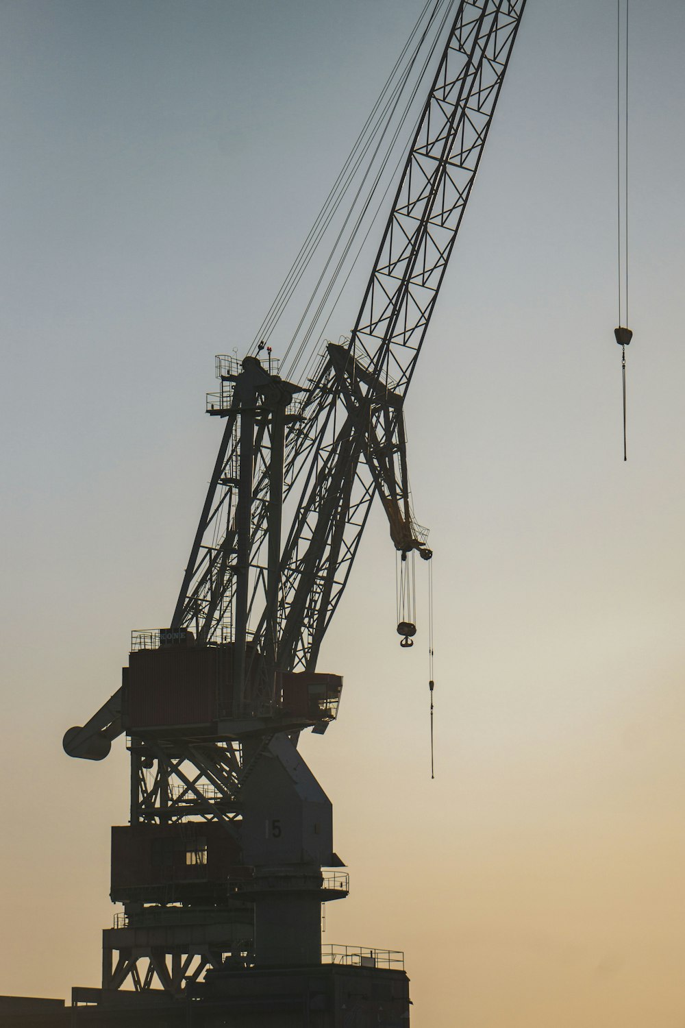 silhouette of crane under cloudy sky during daytime