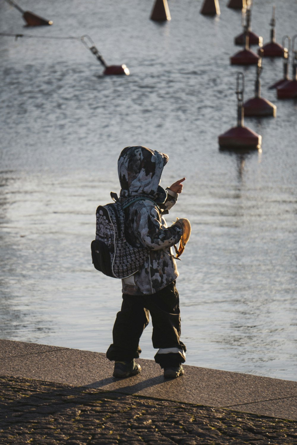 person in black and white checkered long sleeve shirt and black pants standing on beach shore