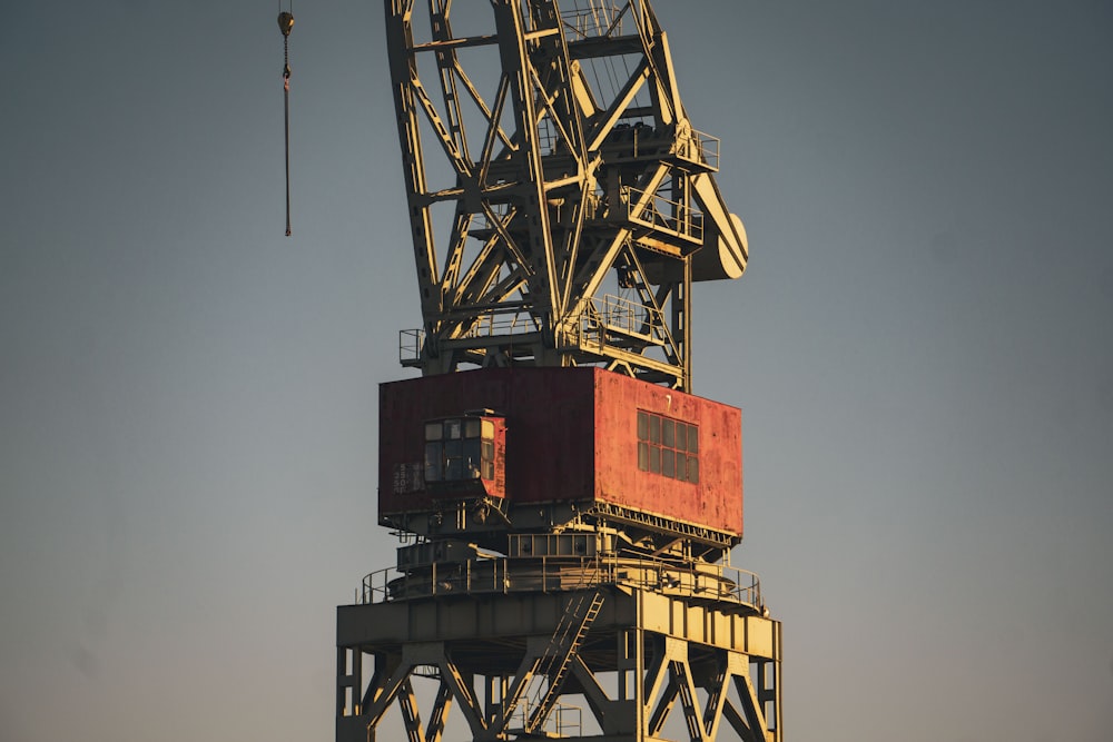 orange and black crane under blue sky during daytime