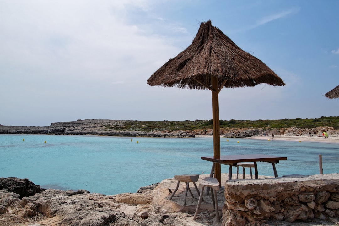 brown wooden beach lounge chair on beach shore during daytime