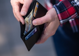 person holding black and orange box