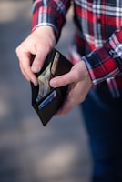 person holding a wallet searching for money